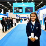 "Teknofest Young Innovator"**

A young Turkish student, fully clothed in modest, modern clothing suitable for a technology competition, stands proudly in front of a futuristic project display at Teknofest (Turkey's largest aerospace and technology festival). The project incorporates elements of robotics and sustainable energy.  The background features other students and displays, creating a sense of innovation and excitement.  Appropriate attire, safe for work, professional, perfect anatomy, correct proportions, well-formed hands, natural pose, high quality, family-friendly.

**